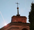 A stork sitting in a nest on the roof of an old church in the rays of the evening sun Royalty Free Stock Photo