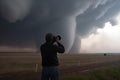 storm chaser, with camera in hand, capturing up-close shots of tornado touching down Royalty Free Stock Photo