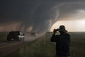 storm chaser capturing breathtaking shots of tornado touching down in field Royalty Free Stock Photo