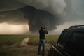 storm chaser takes a dramatic shot of tornado with smoke and debris swirling around