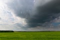 Storm cloud over a green field in the evening Royalty Free Stock Photo
