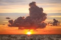 Storm Cloud over Setting Sun in Ocean Royalty Free Stock Photo