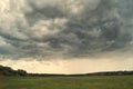 Storm cloud over yellow green fields forests and hills Royalty Free Stock Photo