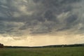 Storm cloud over yellow green fields forests and hills Royalty Free Stock Photo