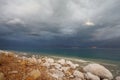 The storm cloud and rocks, overgrown with salt Royalty Free Stock Photo