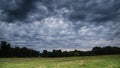 Storm clouds in a bright green meadow Royalty Free Stock Photo