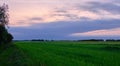 Storm clouds comming over fields in springtime sunset