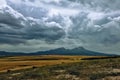 Storm clouds gather over the volcano. The beautiful Hassan volcano rises on the plain Royalty Free Stock Photo