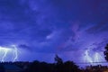 Storm clouds with lightning strike bolts passing over night city Royalty Free Stock Photo