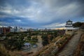 Storm clouds over historic Akashi Castle lookout tower at sunset