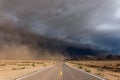 Storm clouds over a long empty road