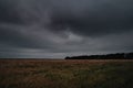 Storm clouds over wheat field. Danger weather with dark sky over fields Royalty Free Stock Photo