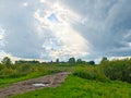 Storm clouds, puddles and mud at a rural road fork - dramatic countryside landscape Royalty Free Stock Photo