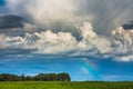 Storm clouds with rainbow part and sunrays Royalty Free Stock Photo