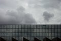 Storm clouds reflect in windows of office building/ Mirror windows with overcast sky reflections/ corporate building facade Royalty Free Stock Photo