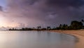 Storm clouds rolling over a tropical beach at sunset. The sea is perfectly calm. Royalty Free Stock Photo