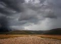 Storm coming in over Castelluccio di Norcia plain, in Umbria, Italy. Bad weather. Low angle view, big sky.