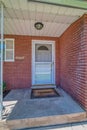 Storm door and gray front door at home facade with red brick stone wall Royalty Free Stock Photo