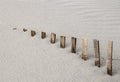 Storm fence disappears into drifting beach sand dune Royalty Free Stock Photo