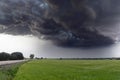 Storm forming dark clouds over green grass field. Royalty Free Stock Photo