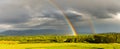 A storm front with numerous rainfalls passes over the mountains, the sun came out from behind the clouds, a colorful rainbow