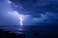 A storm front with rain and curved lightning striking the sea near an abandoned marine science platform Royalty Free Stock Photo