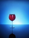 Storm in a glass of red wine on a blue background Royalty Free Stock Photo