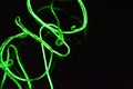 Toxic green lime lighting with a specific pattern. Woven filaments, cable, wires with outgoing light. Neon electroluminescent wire