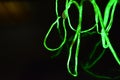 Toxic green lime lighting with a specific pattern. Woven filaments, cable, wires with outgoing light. Neon electroluminescent wire
