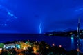 A storm lights up the night sky as lightning hit the horizon. Lightning strikes over the sea long single exposure. Royalty Free Stock Photo