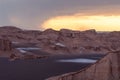 Storm with lots of rain coming to the Lut desert, Iran, in the golden hour. Stormclouds gather while the horizon glows