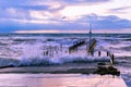 Waves over boat jetty at sunset. Royalty Free Stock Photo