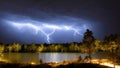 Storm over the lake. Lightning over the water at night Thunderstorm light the dark cloudy sky - created by generative AI Royalty Free Stock Photo