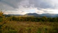 Storm over the mountains in the summer season with green meadow illuminated of the Sun Royalty Free Stock Photo