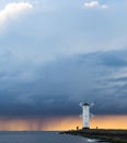 Storm passing over the lighthouse at sunset Royalty Free Stock Photo