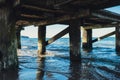 Storm sea waves under wooden pier in dramatic background wallpaper design. Seascape with running splashing sea waves Royalty Free Stock Photo