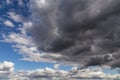 Storm sky. Dark grey and white big cumulus clouds against blue sky background, cloud texture Royalty Free Stock Photo