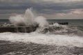 Storm waves over harbor at sea. Sea storm with waves crashing against the pier