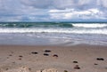 Storm weather on Baltic sea, landscape with sand beach with focus on front stones Royalty Free Stock Photo