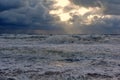 Storms at sea and wind, through clouds tries to escape the ray of sun. Royalty Free Stock Photo