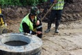 Stormwater runoff, open hatch, Sand and gravel during the construction of the highway. The worker measures the line with