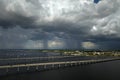 Stormy clouds forming from evaporating humidity of ocean water before thunderstorm over traffic bridge connecting Punta Royalty Free Stock Photo