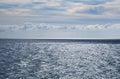 Stormy grey sea, calm before the storm, blue sky with some white Royalty Free Stock Photo