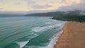 Stormy ocean surf foaming sand drone view. Sea water waves washing sandy beach