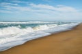 Stormy ocean waves, sand beach, and cloudy sky background Royalty Free Stock Photo