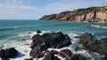 Stormy powerful sea waves splashing at rough seashore cliffs. Aerial shore rocks