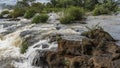 A stormy river rushes rapidly along a rocky bed.