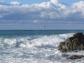 Stormy sea and sailboat along Tuscany coastline in Livorno, Italy