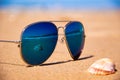 Stormy sea and shell are reflected in the mirror sunglasses on tropical beach Royalty Free Stock Photo