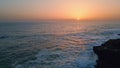 Stormy sea sunset horizon landscape slow motion. Foamy water crashing dark rocks Royalty Free Stock Photo